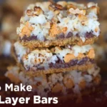 Top view of freshly baked Easy Seven Layer Bars with layers of chocolate chips, coconut, graham cracker crust, and condensed milk — a rich, gooey dessert perfect for quick baking.