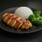 Teriyaki chicken with rice and steamed broccoli on a white plate