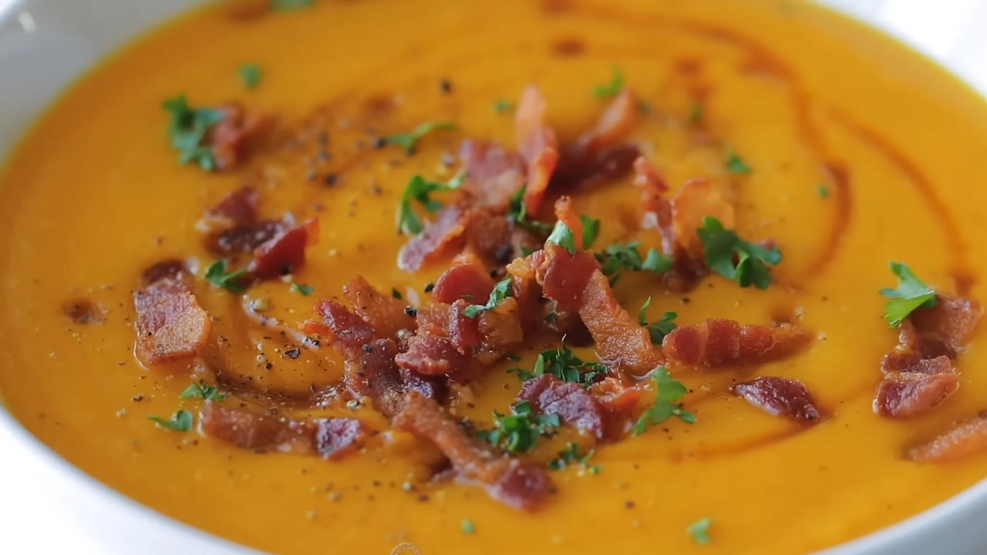 Creamy Butternut Squash Soup Recipe (Easy & Cozy) 1 Creamy butternut squash soup with a swirl of cream and fresh herbs in a bowl