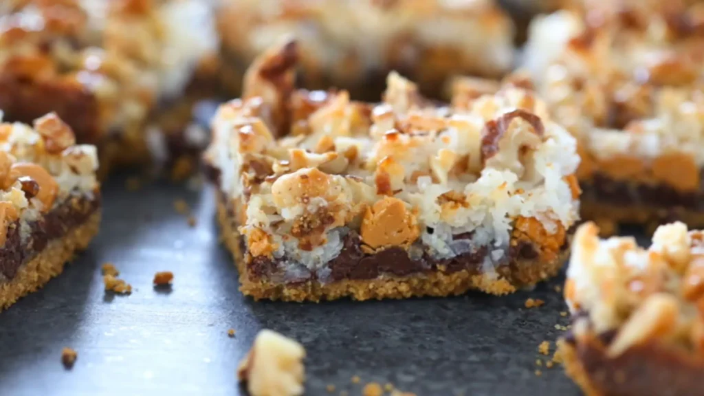 Easy Seven Layer Bars Recipe – No Mixer Needed 3 Sliced seven layer bar showing condensed milk and chocolate layers