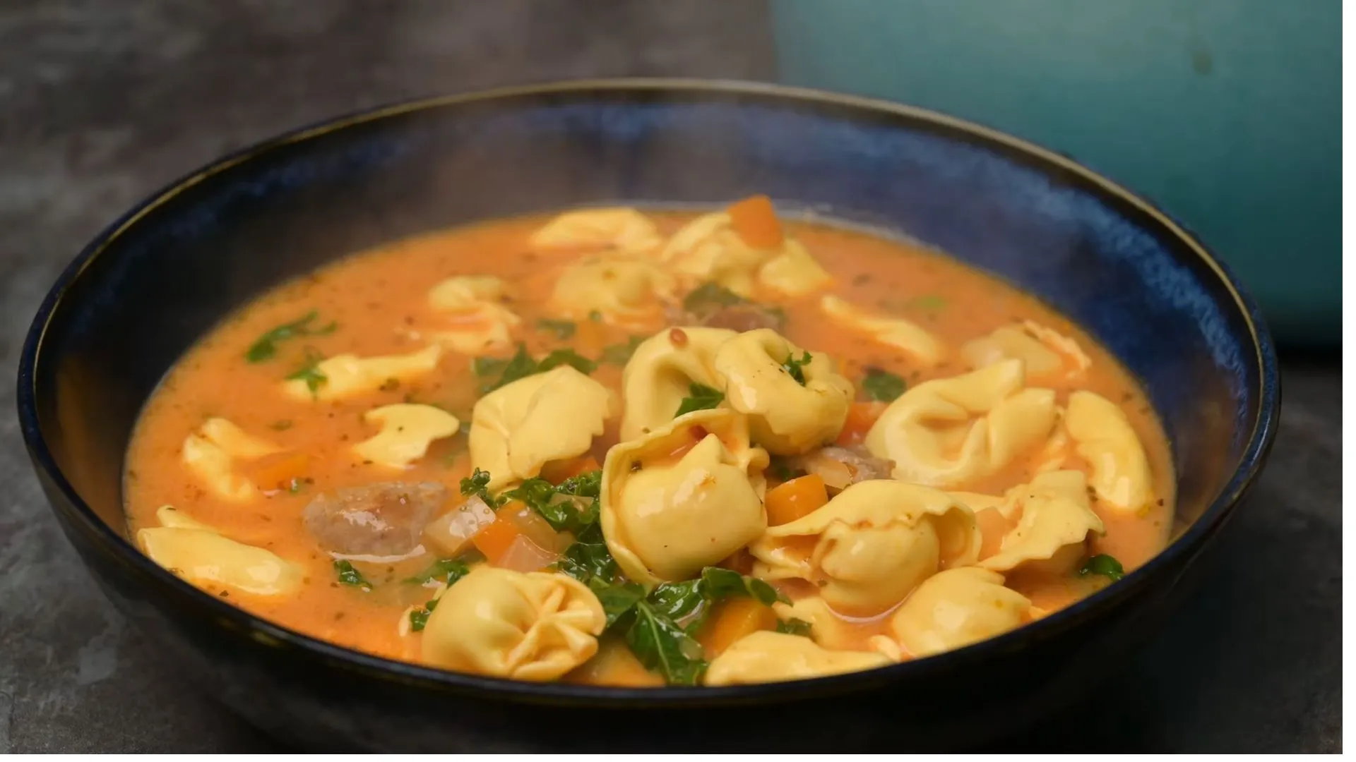 Cozy Sausage Tortellini Soup Recipe 4 Bowl of sausage tortellini soup with bread and spoon for serving