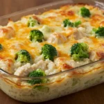 Cheesy chicken broccoli rice casserole baked in a glass dish with golden melted cheese on top.
