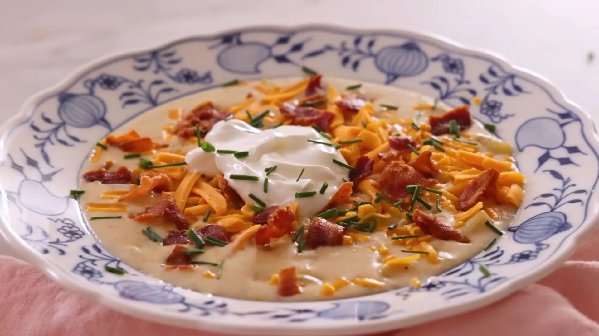 Cozy Potato Onion Soup Recipe 1 Creamy potato onion soup topped with fresh herbs in a white bowl