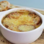 Golden, cheesy French onion soup in a rustic bowl with toasted bread.