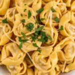 Creamy tortellini carbonara topped with parmesan and herbs