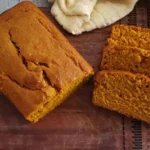 Freshly baked homemade pumpkin bread sliced on a wooden board.