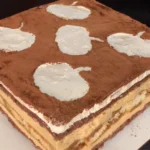 Pumpkin spice tiramisu topped with cinnamon in a glass baking dish