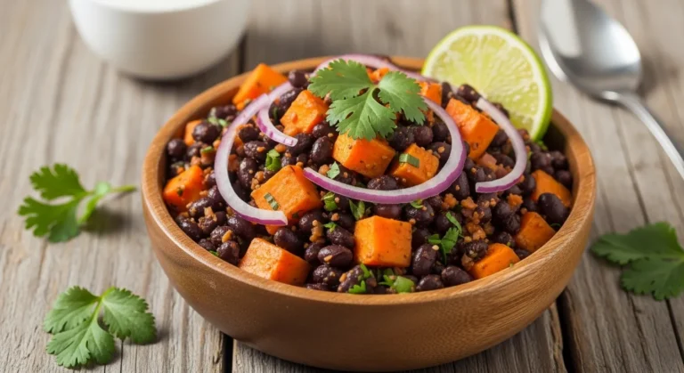 Roasted Sweet Potato Black Bean Salad Recipe 8 Overhead shot of roasted sweet potato black bean salad with corn, red onion, and cilantro in a white serving bowl.