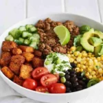 Healthy Sweet Potato Taco Bowl with black beans, corn, avocado, and lime dressing.