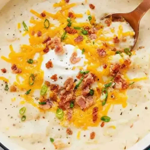 Close-up of creamy loaded cheesy potato soup with melted cheese and bacon