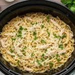 Creamy crock pot angel chicken served over angel hair pasta with parsley garnish