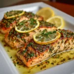 Close-up of baked salmon with flaky texture and herbs