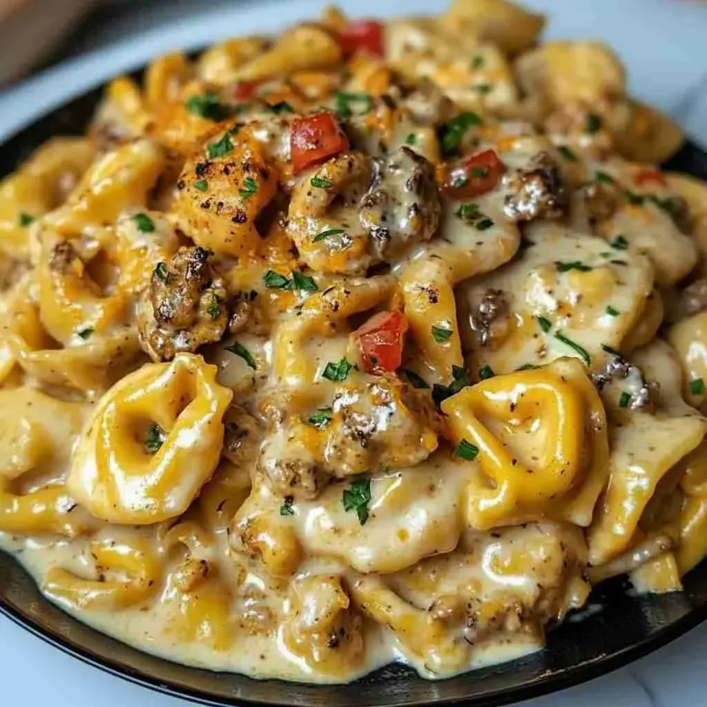 Loaded Cajun Alfredo tortellini served in a bowl topped with parsley and Parmesan