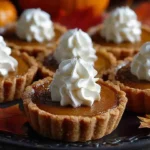 Mini pumpkin pies topped with whipped cream and cinnamon