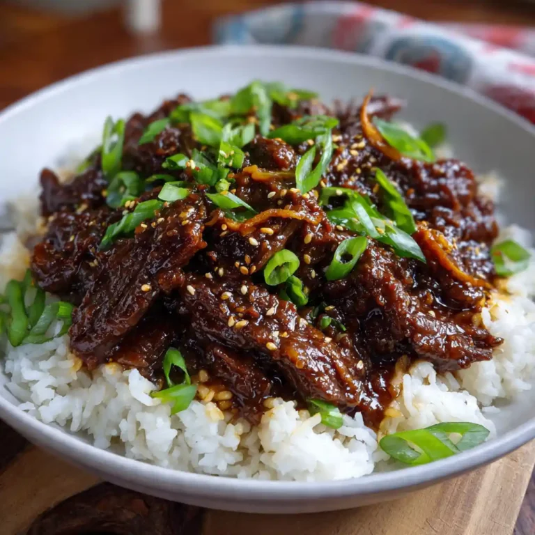 Slow Cooker Mongolian Beef served over rice with green onions and sesame seeds